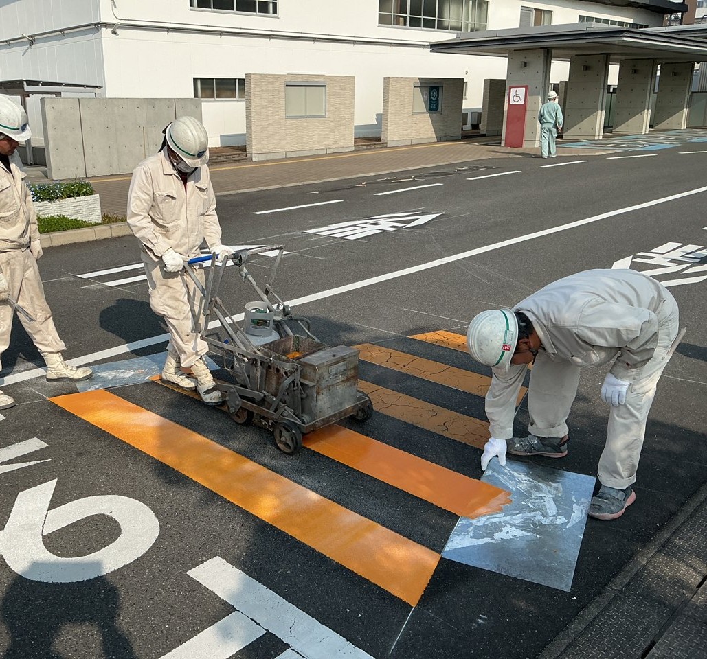 スタッフが道路標示を施工する様子